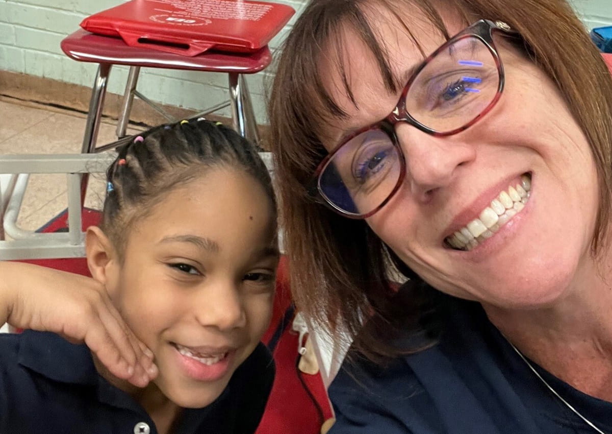 An educator connects with a student as they take a selfie.